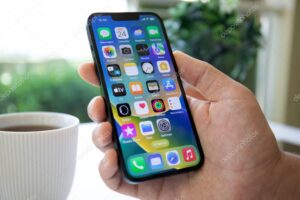 Alanya, Turkey - May 24, 2023: Man hand holding iPhone 14 with home screen IOS 16 on the screen